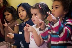 Children following along with the teacher during circle time